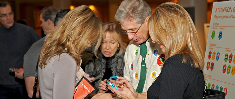 Attendees engaging with gamification platform utilizing conference app sponsorship