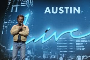 Matt McConaughey speaking on stage in Austin
