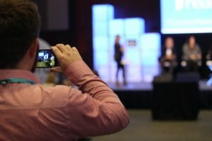 Person photographing a Tech Pitch Presentation on his phone