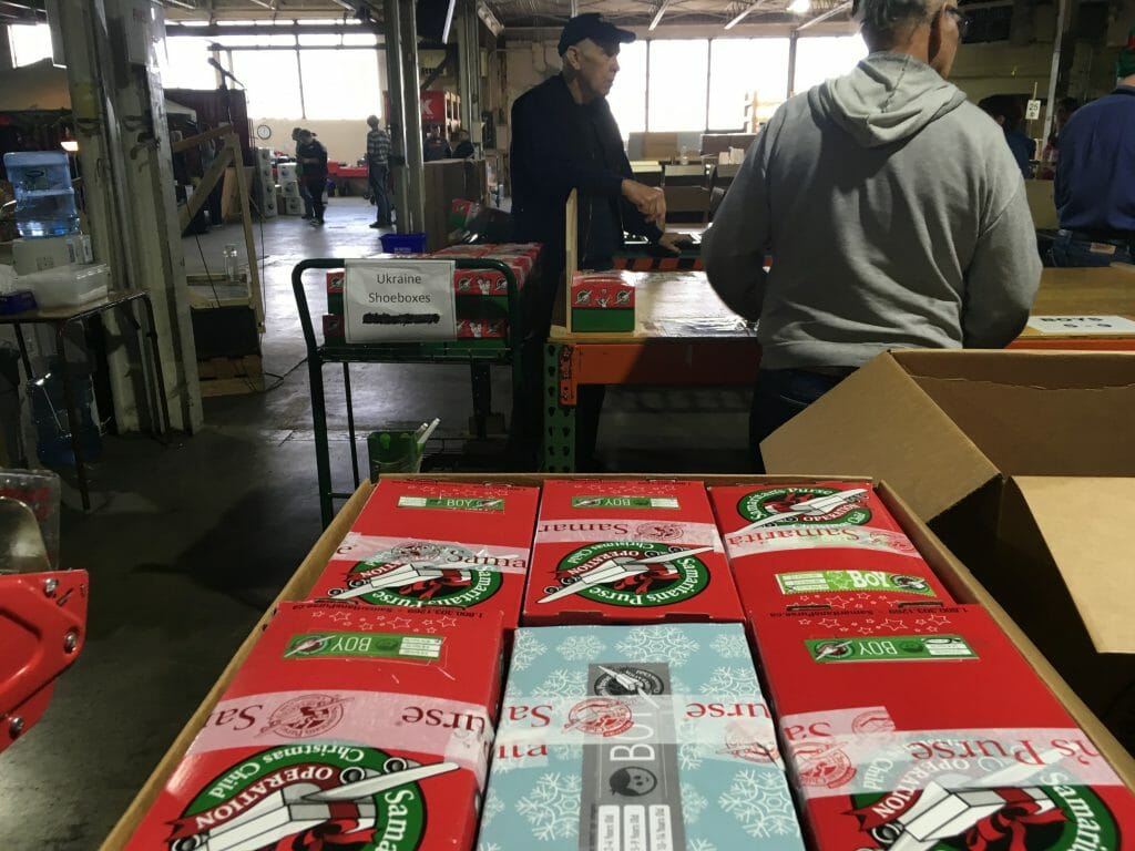 Shoeboxes getting packed into large boxes for shipping