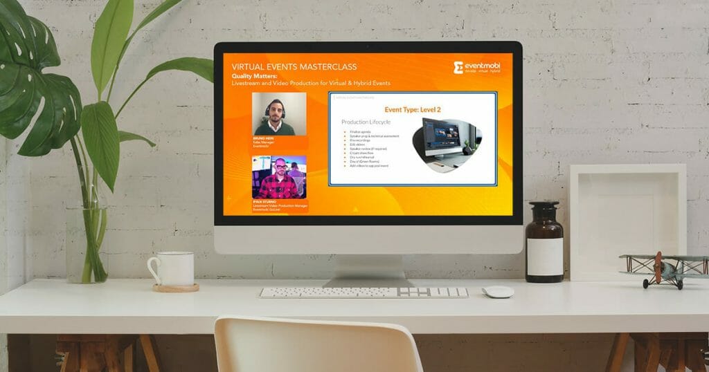 A computer screen shows a professional live stream production for a virtual conference, with presentation slides, speaker videos and a branded background.