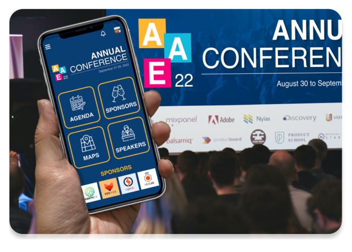 Mobile phone with event app held up with crowd viewing matching live display on conference screen