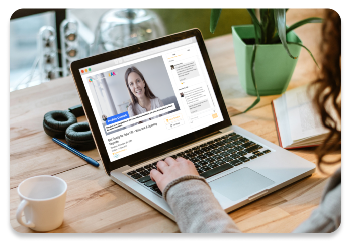 Person attending virtual event on laptop computer, watching live video while using chat feature