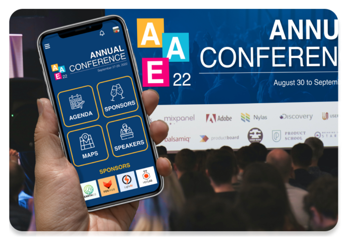 Eine Hand mit Smartphone, auf dem die Event-App geöffnet ist. Im Hintergrund eine Veranstaltung mit Publikum, das dem Live-Display auf einem Konferenzbildschirm folgt.