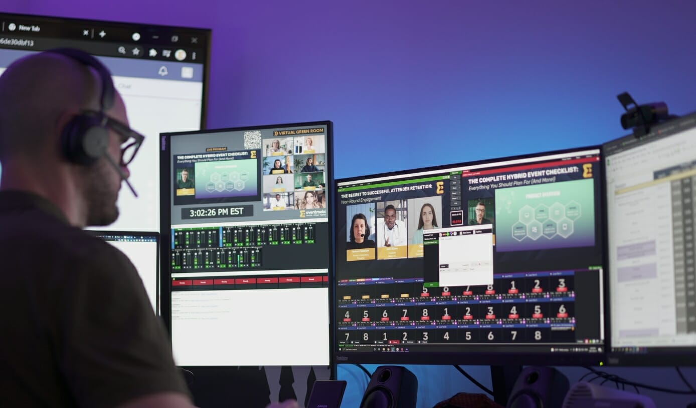 Ein Profi bei der Videoproduktion an mehreren Bildschirmen und mit Studioeinrichtung für das Streaming
