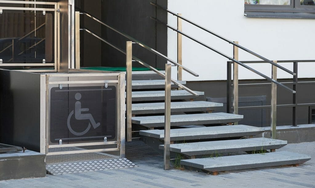 A wheelchair elevator beside a staircase.