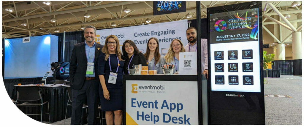A group photo of happy EventMobi employees at the EventMobi CMEE booth. 