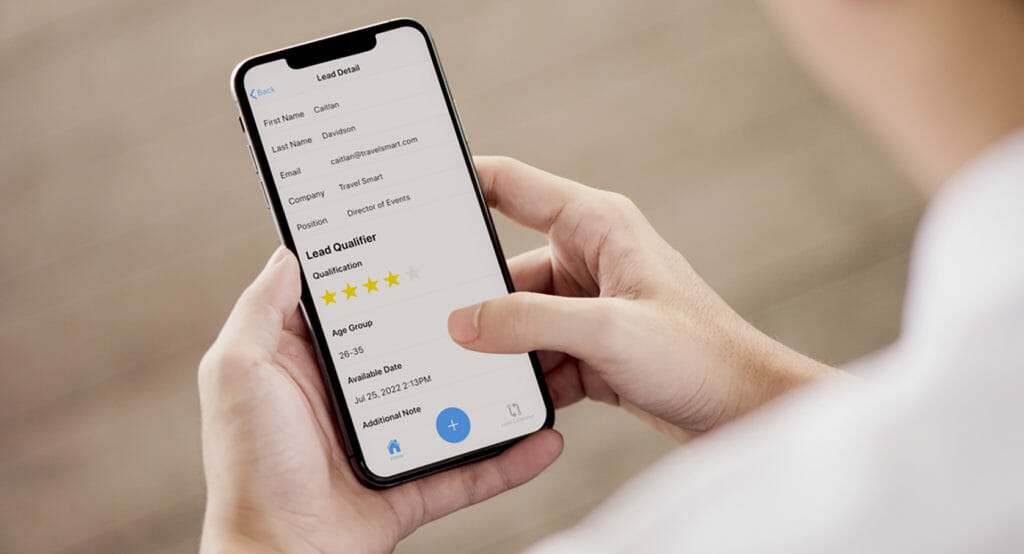 A person looks at lead details in their smartphone using EventMobi's lead capture software. 
