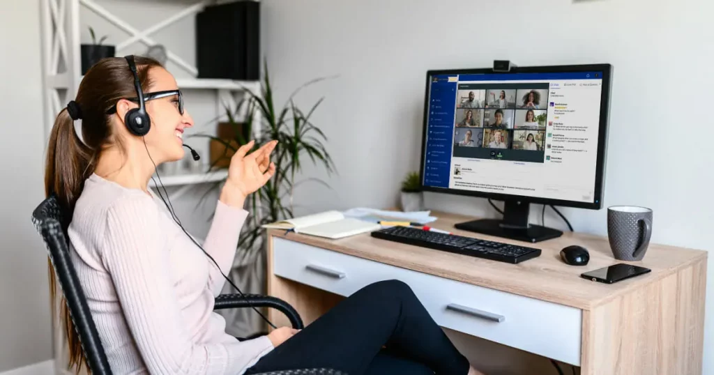 Eine Frau an einem Computer, auf dem ein Meeting einer Onlinecommunity läuft.