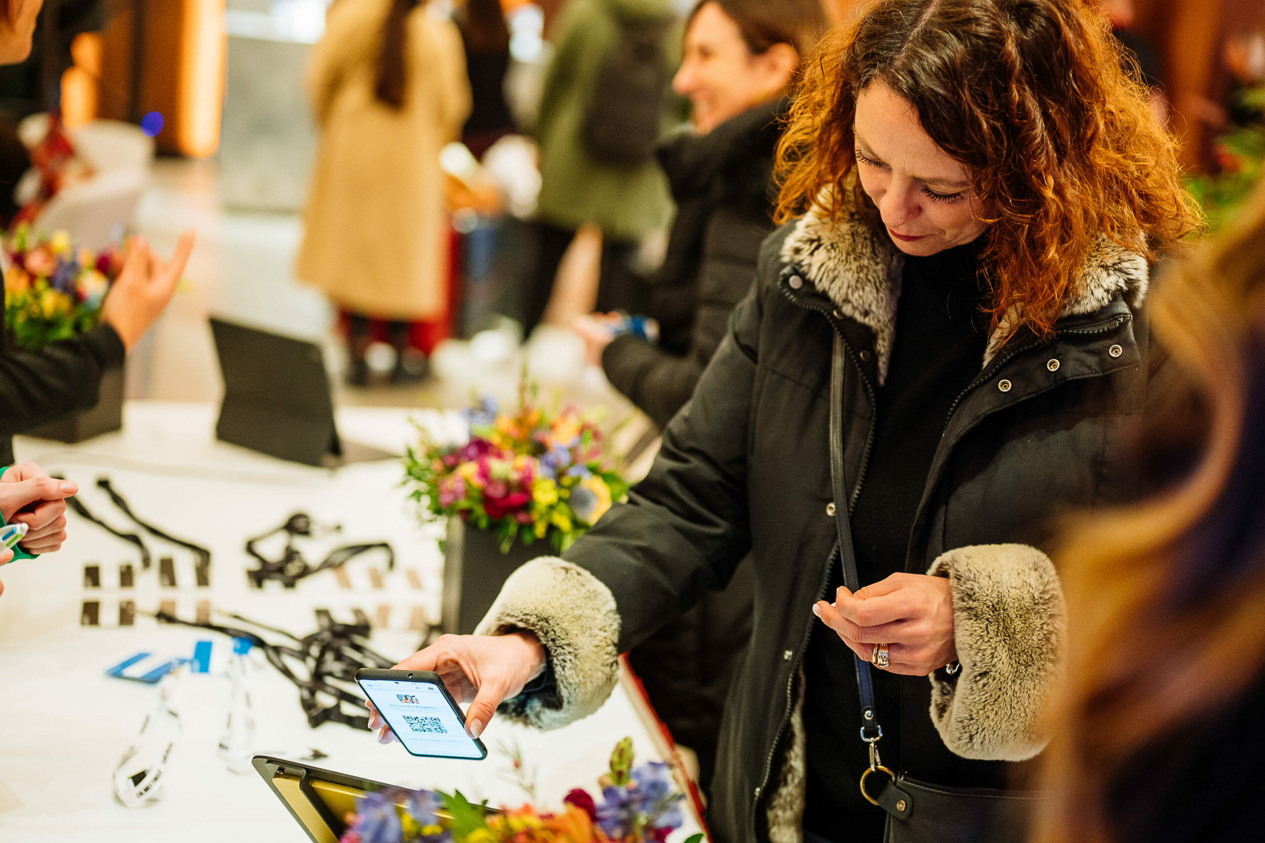 Eine Event-Teilnehmerin checkt sich selbstständig beim Einlass per QR-Code ein.