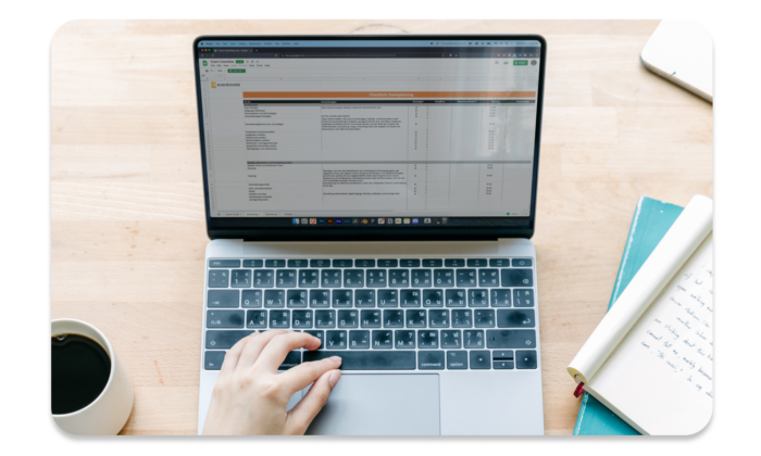 Eventplaner*in arbeitet am Laptop mit der großen Eventplanungs-Checkliste.