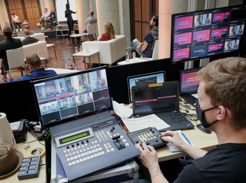 Livestream-Produktion bei einer Hybrid-Veranstaltung: AV-Spezialist überwacht mehrere Bildschirme