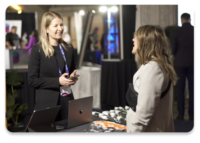 An attendee and booth staff talking at an event.