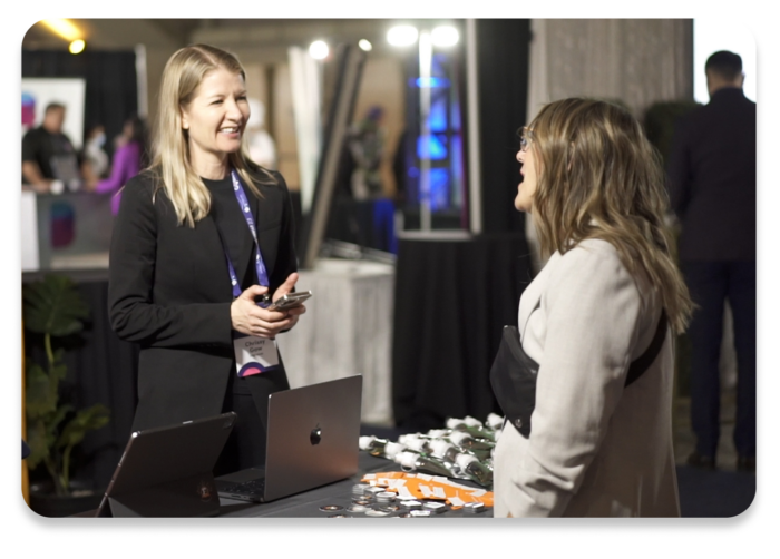 An attendee and booth staff talking at an event.