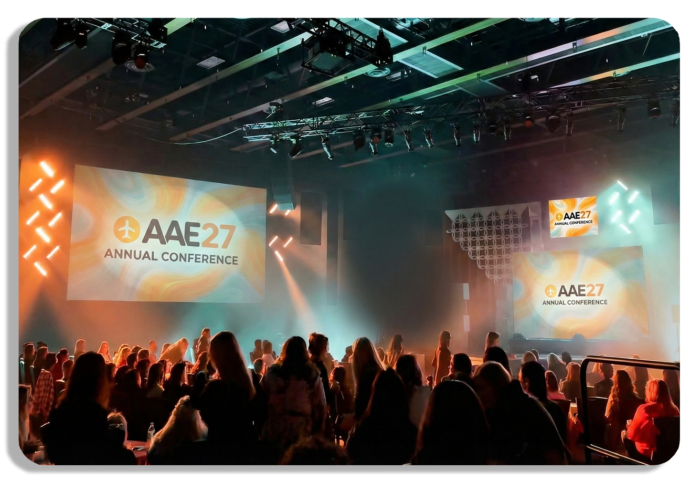 Speaker stage with a large audience at an event conference.