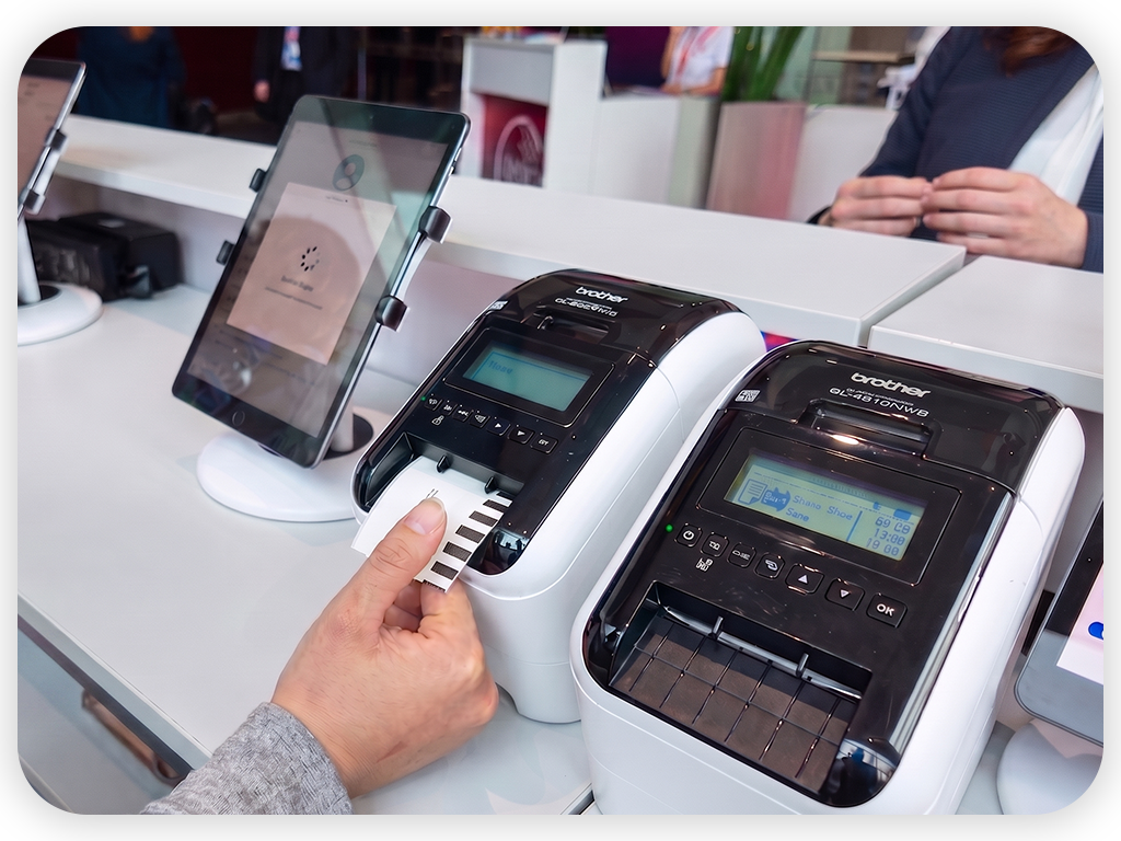 Event-Mitarbeiter druckt am Registrierung Counter ein Event-Badge mit BadgeON™ von EventMobi.